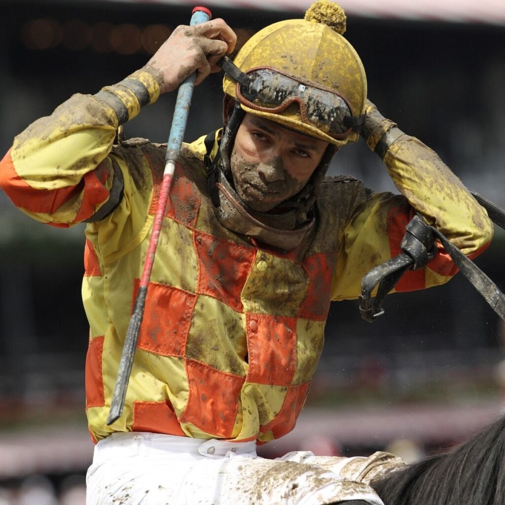 A jockey after a muddy horse race.
